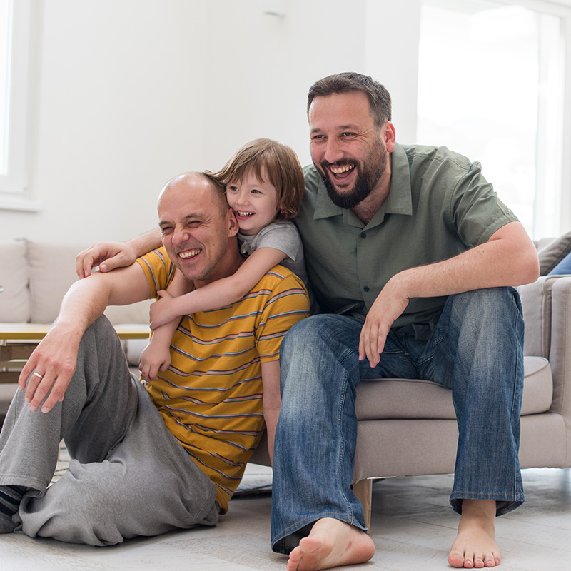 Gay Couple in Louisiana on couch with child