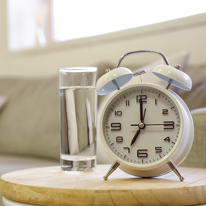 therapy_louisiana Clock and glass of water on table for therapy session with Kelley Massengale - Fees, Insurance, Cancellation Policy